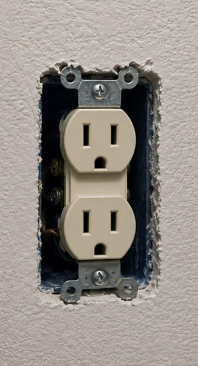 Older ungrounded electrical outlet in a Berkeley home before upgrading to GFCI protection.